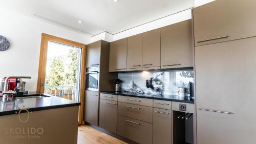 a kitchen with stainless steel appliances and a window at Haus Golmenegg, Riederalp in Riederalp
