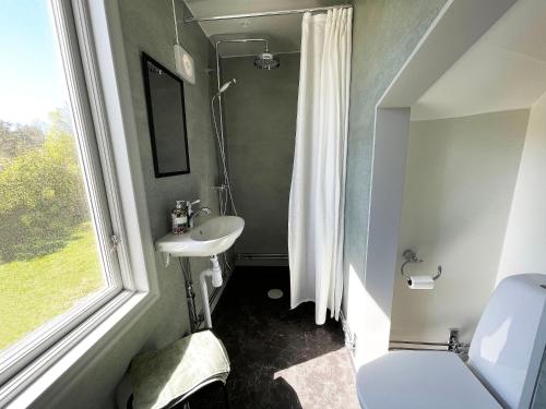a bathroom with a sink and a toilet and a window at Pensionat Grisslehamn in Grisslehamn