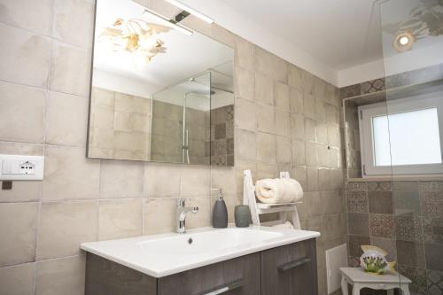 a bathroom with a sink and a mirror at Mille Lire - Family suites in Monopoli