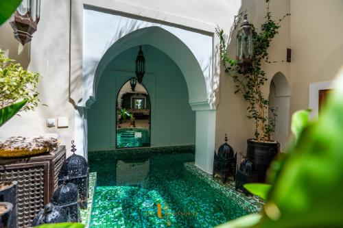 un patio con piscina en una casa con azulejos verdes en Riad El Youssoufi, en Marrakech