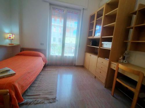 Un dormitorio con una cama y un escritorio y una ventana. en CasaTreFontane, en Bovalino Marina