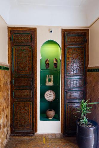 a room with two wooden doors next to at Riad El Youssoufi in Marrakech