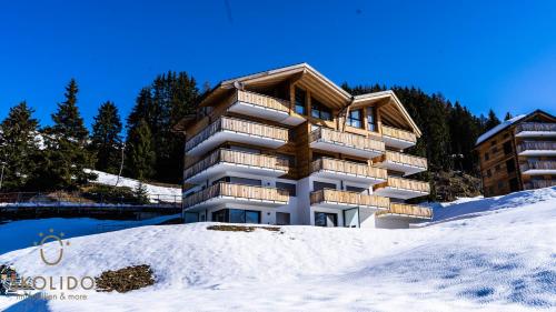 a apartment building in the snow in the mountains at Haus Golmenegg, Riederalp in Riederalp