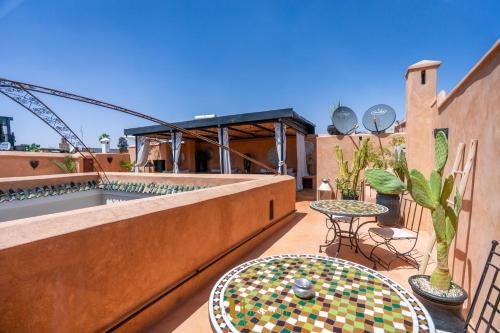 a patio with a table and a pool on a building at Riad El Youssoufi in Marrakech