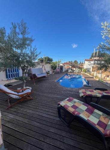 a deck with lounge chairs and a swimming pool at VILLA MIAMI in Miami Platja