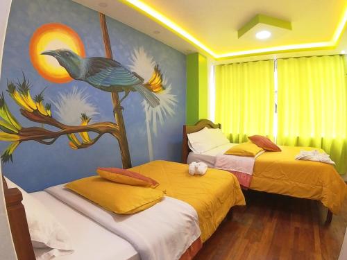 2 camas en una habitación con un cuadro en la pared en Hostal El Rey, en Baños