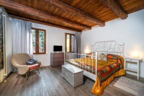 um quarto com uma cama, uma secretária e uma cadeira em Jacaranda em Udine