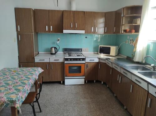 una cucina con mobili in legno, una stufa e un lavandino di Casa Stegmann a Pringles