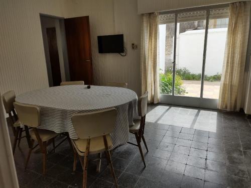 una sala da pranzo con tavolo, sedie e una finestra di Casa Stegmann a Pringles