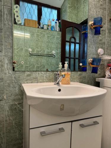 uma casa de banho com um lavatório branco e um espelho. em Joy City Stay Ungureanu 6B em Timisoara
