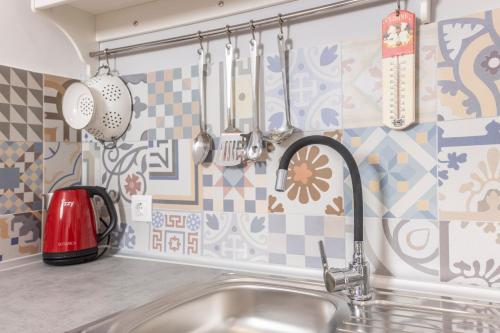 a kitchen with a sink and utensils on the wall at BleVista Apartments in Polykhrono