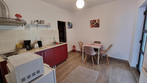 kuchnia ze stołem oraz kuchnia z kuchenką mikrofalową w obiekcie Salt Orchid Apartments w mieście Turda