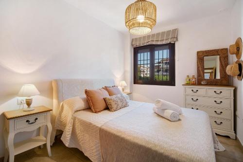 a bedroom with a bed and a table and a mirror at Apartamento en Playa de La Barrosa in Chiclana de la Frontera