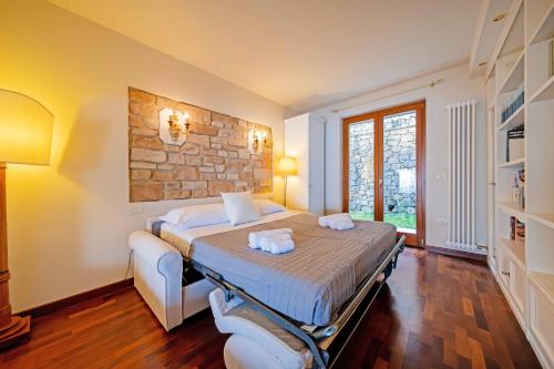 a bedroom with a bed and a stone wall at ApartmentsGarda - Residence Pasola in Brenzone sul Garda