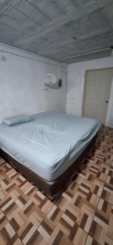a white bed in a room with a wooden floor at Apartatamento pequeño amueblado in San Salvador