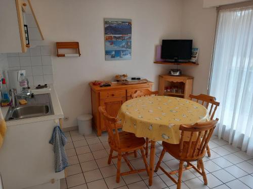 une cuisine avec une table et des chaises et une télévision dans l'établissement Studio pour 3 pers. à Châtel avec balcon, parking, près navettes et centre. Exposition Sud/Ouest. - FR-1-676-115, à Châtel