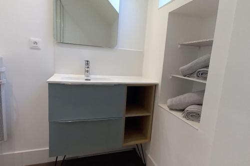 a bathroom with a sink and a mirror and towels at Gîte le 7 de Coeur, Baie Mont St Michel in Dragey