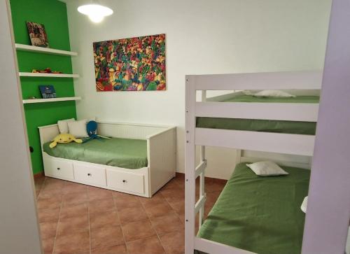 een kleine kamer met 2 stapelbedden en een bed bij La Casa di Azul in Levanzo