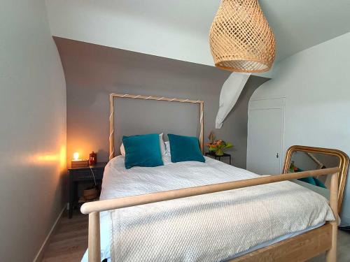 a bedroom with a bed with blue pillows on it at Appartement et Maison Espace Mayenne in Laval