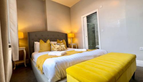 a bedroom with a bed with yellow sheets and a window at Central - Business Stays - Relocating in Harrogate