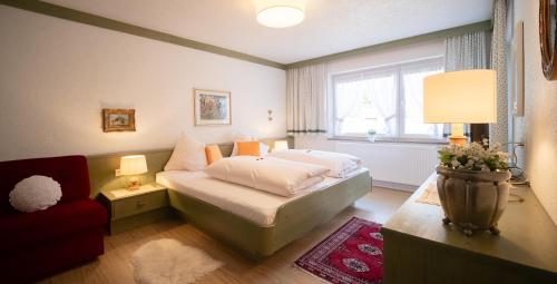 a bedroom with a bed and a couch and a window at Försterhäusl in Seefeld in Tirol