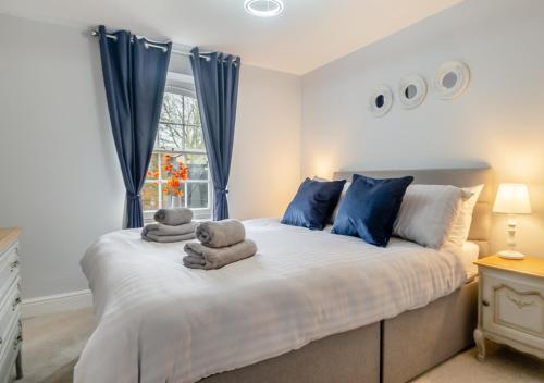 a bedroom with a large bed with towels on it at The Old Mill Cottage - Norfolk in Fakenham
