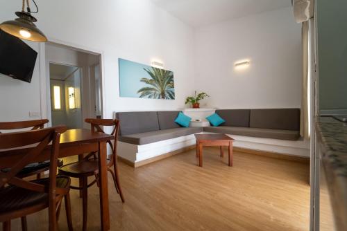 a living room with a couch and a table at MAKĀI Bungalows in Playa del Aguila