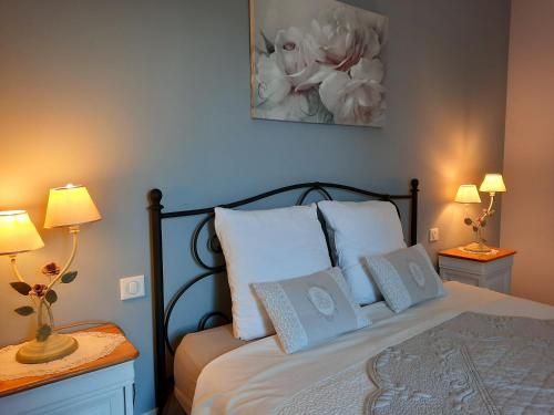 ein Schlafzimmer mit einem Bett mit weißen Kissen und zwei Lampen in der Unterkunft L Olivadou B&B in Trans-en-Provence