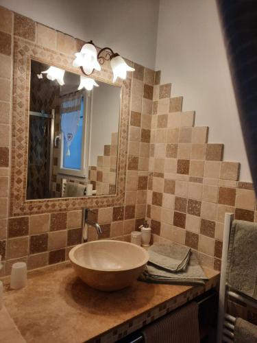 a bathroom with a bowl sink and a mirror at L Olivadou B&B in Trans-en-Provence