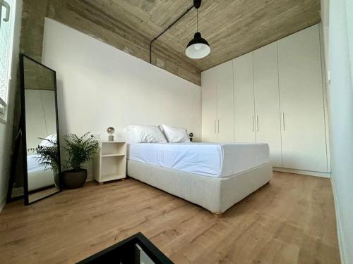 - une chambre avec un grand lit blanc et un miroir dans l'établissement Industrial Loft Comfort Living, à Héraklion