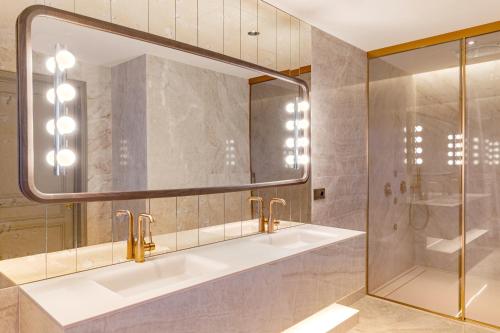 a bathroom with two sinks and a mirror at Casa Faraona Luxury Residences in Madrid