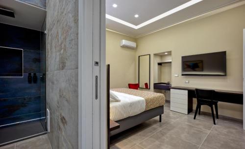 a bedroom with a bed and a desk and a television at Palm Suites in Naples