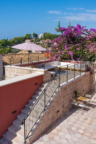 a set of stairs with a table and purple flowers at Cavtat Old School in Cavtat