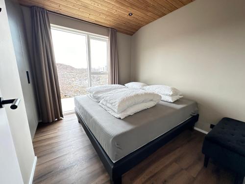 a bedroom with a bed with a large window at Holiday Home in Húsafell