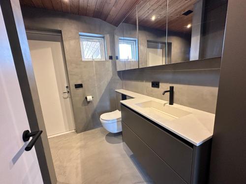 a bathroom with a sink and a toilet at Modern and family friendly Chalet with Ouside Spa - Birta Rentals in Húsafell