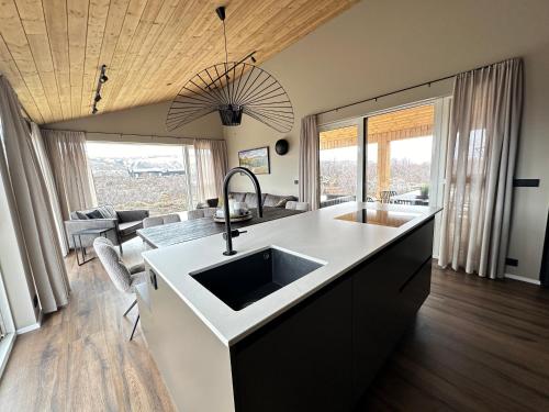 a kitchen with a sink and a living room at Modern and family friendly Chalet with Ouside Spa - Birta Rentals in Húsafell