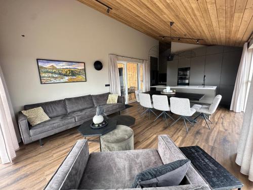 a living room with a couch and a table at Modern and family friendly Chalet with Ouside Spa - Birta Rentals in Húsafell