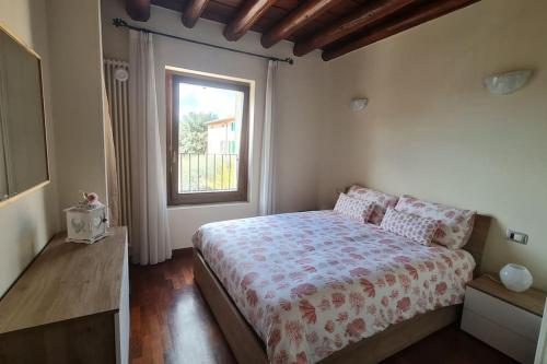 een slaapkamer met een bed en een raam bij Corte primavera. Custoza, lago di Garda, Verona in Villafranca di Verona