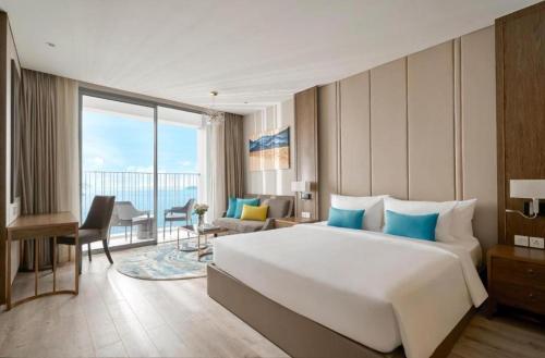um quarto de hotel com uma cama grande e uma janela grande em Best View Panorama Suites managed by MLB em Nha Trang