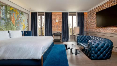 a hotel room with a bed and a couch and a tv at Casa Faraona Luxury Residences in Madrid