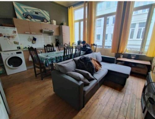 ein Wohnzimmer mit einem Sofa und eine Küche mit einem Tisch in der Unterkunft Ana habitación privada in Antwerpen