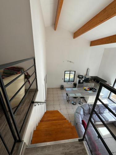 une chambre mansardée avec un bureau et une table dans l'établissement Gite La CRAU & piscine - Oliveraie Bio Mas de Cargane, à Entressen