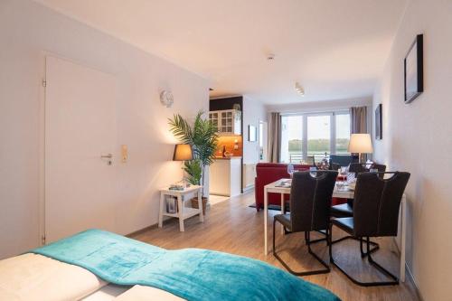 a room with a bed and a dining room at Haus-Windjammer-Wohnung-15-Strandkoje in Heiligenhafen