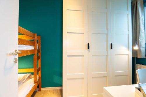 a bedroom with white cabinets and a bunk bed at Haus-Windjammer-Wohnung-15-Strandkoje in Heiligenhafen