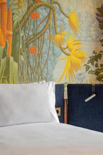 a bedroom with a bed and a wall with a painting at Casa Faraona Luxury Residences in Madrid