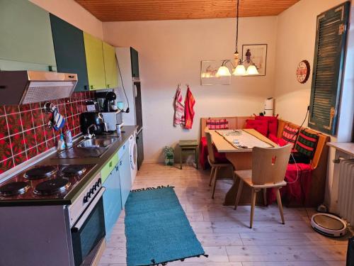 uma cozinha com um fogão e uma mesa com uma sala de jantar em Ferienwohnung Maria 5 em Haundorf