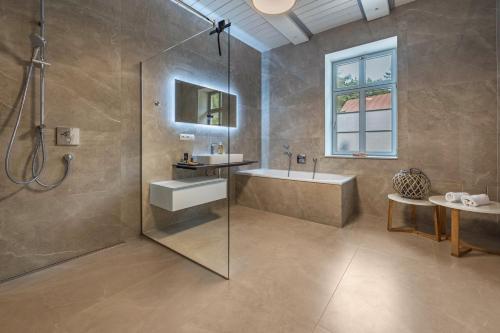 La salle de bains est pourvue d'une douche, d'un lavabo et d'une baignoire. dans l'établissement Suite mit Wintergarten, à Dedelstorf