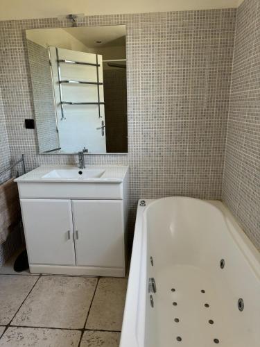 une salle de bain avec une baignoire blanche et un lavabo dans l'établissement Gite La CRAU & piscine - Oliveraie Bio Mas de Cargane, à Entressen