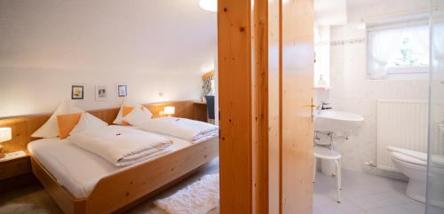 a bedroom with a bed and a sink and a toilet at Försterhäusl in Seefeld in Tirol