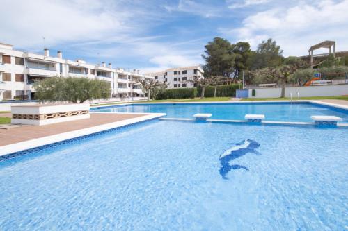 a large swimming pool with a dolphin in the water at La Galera in Torredembarra